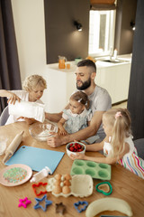 Pleasant nice family sitting in at the table