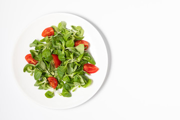 Fresh green salad with tomatoes on a white background, flat lay