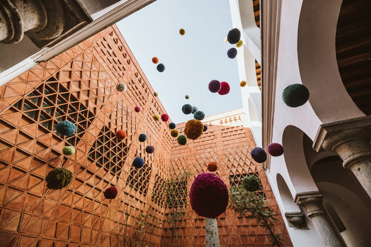 art installation of hanging colored yarn balls in historic oaxaca