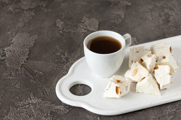 Italian festive torrone. Nougat with almonds and cup of coffee.