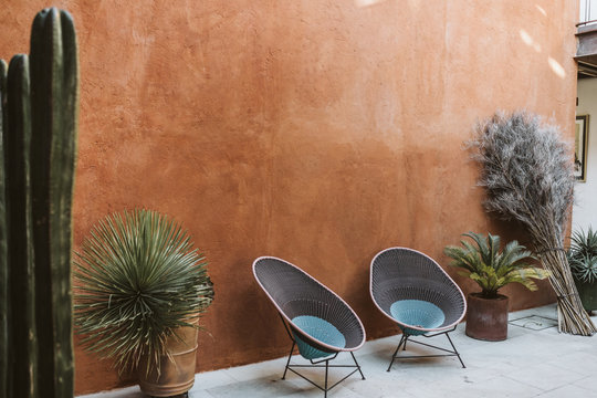 outdoor patio space with two empty chairs and potted cacti