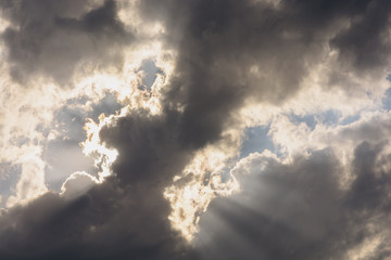 Beautiful sky with storm clouds and glimpses of sun rays through them