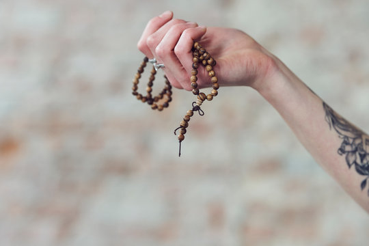 Close up of hands holding wooden necklace