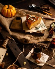 homemade tasty slice of pumpkin orange cheesecake on wooden board on rustic brown table