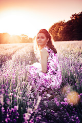 Eine junge wunderschöne Frau steht im romantischem Lavendelfeld