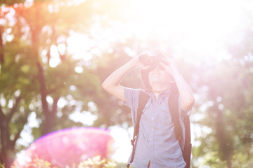 Portrait of little explorer with binoculars in forest. Boy traveler in helmet play in the park. Happy child go hiking with backpack in summer nature. Dream concept.