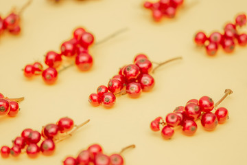 The pattern of juicy sweet fresh red currant berries on a yellow background.