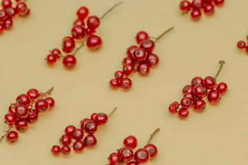 The pattern of juicy sweet fresh red currant berries on a yellow background.