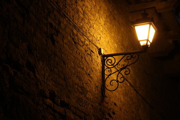 Old vintage street lantern on a brick wall, night background, victorian vintage style © Kateryna