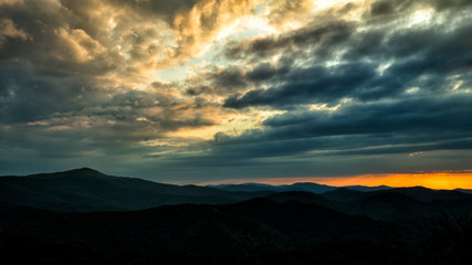 Obraz premium A wonderful sunset in the mountains. Orange sky and dark silhouettes of mountains. Carpathian Mountains landscape. Bieszczady. Poland