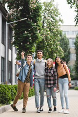 Fototapeta premium smiling and happy teenagers holding american flag and pointing with finger