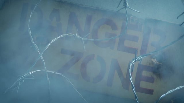 Danger Zone Sign On Wall With Smoke Rising