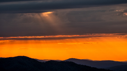 Fototapeta na wymiar A wonderful sunset in the mountains. Orange sky and dark silhouettes of mountains. Carpathian Mountains landscape. Bieszczady. Poland