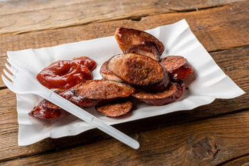 fried sliced sausage -  dish on a paper tray