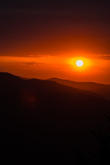 Fototapeta premium A wonderful sunset in the mountains. Orange sky and dark silhouettes of mountains. Carpathian Mountains landscape. Bieszczady. Poland