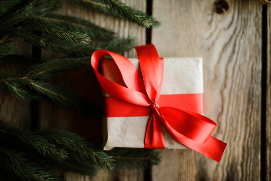 Christmas presents in red ribbon on a wooden background