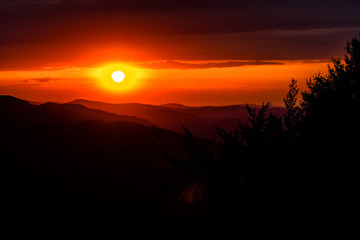 A wonderful sunset in the mountains. Orange sky and dark silhouettes of mountains. Carpathian Mountains landscape. Bieszczady. Poland