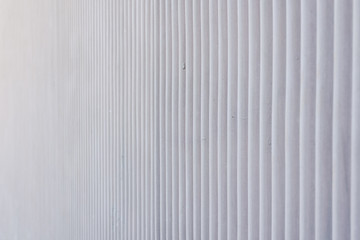 Wavy metal background on a gray wall.