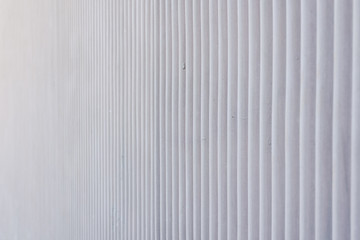 Fototapeta premium Wavy metal background on a gray wall.