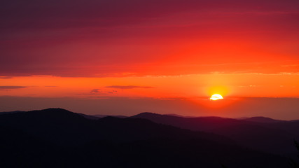 Fototapeta premium A wonderful sunset in the mountains. Orange sky and dark silhouettes of mountains. Carpathian Mountains landscape. Bieszczady. Poland