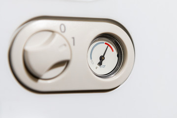 Close up of combi boiler pressure gauge into the red.  High pressure fault