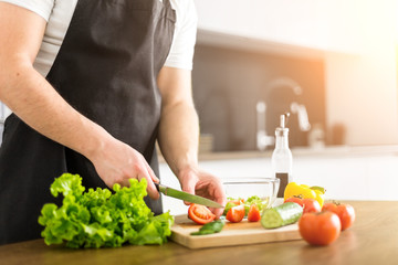 Young trendy man cooking healthy food in the morning