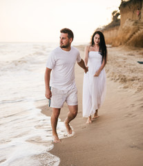 Fototapeta na wymiar Beach couple walking on romantic travel honeymoon vacation summer holidays romance. Young happy lovers.