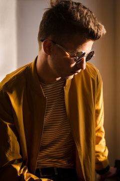 Young man wearing sunglasses sitting indoors