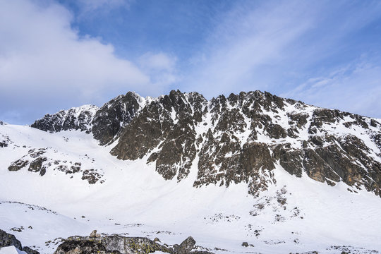 Winter view of the highest mountain of Slovakia and High Tatras, Gerlach mountain. Gerlachovsky stit in winter. High alpine mountain landscape covered with snow and ice. Blue vibrant sky.