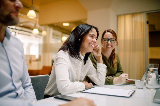 Smiling business people sitting at conference table in office