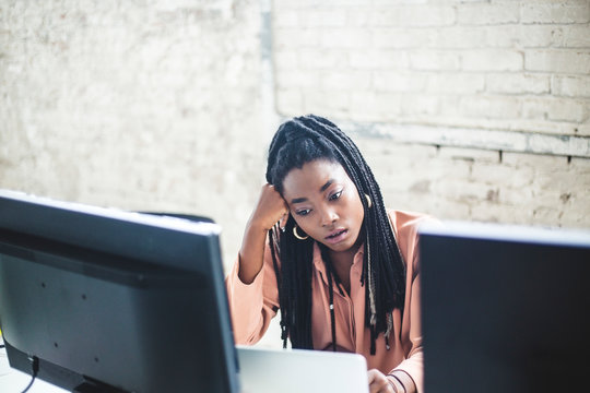 High angle view of young female computer hacker coding at desk in office