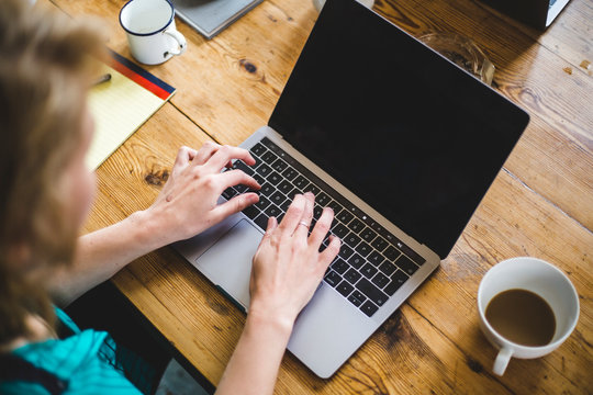High angle view of female IT expert coding in laptop at desk