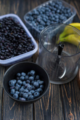 Cooking smoothie blender of wild purple blueberries, bananas. Raw vegan dessert in coconut eco bowl. Idea recipe healthy diet breakfast. Concept losing weight, healthy lifestyle. Vertical