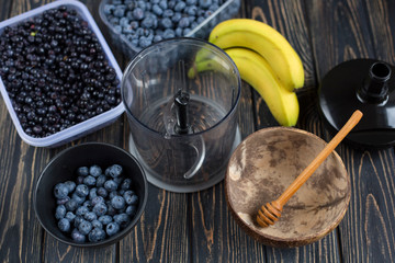 Process of making smoothie blender of wild purple blueberries, bananas. Raw vegan dessert in coconut eco bowl. Idea recipe healthy diet breakfast. Concept losing weight, healthy lifestyle.