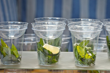 Multicolored fruit drinks close-up. Non-alcoholic drinks in plastic cups at the festival. Cocktails with juice and greens.
