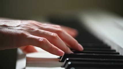 Closeup of female hands playing on a piano keyboard