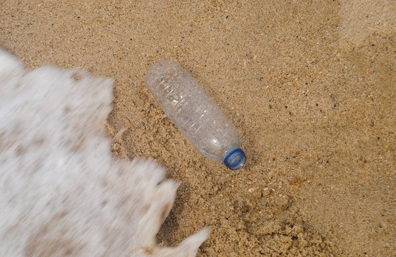 Pl&aacute;stico nos oceanos, garrafa de pl&aacute;stico que deu &aacute; costa numa praia