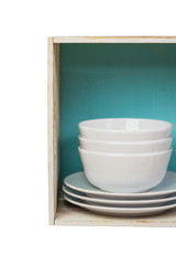 Kitchen dishes in a boxlike rustic shelf isolated