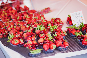 Fresh strawberries and green peas for sale on local food market