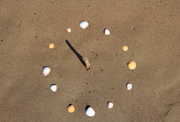 Sundial on beach made of seashells, and a twig. At the Mediterranean beaches, Turkey