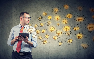 Happy businessman using tablet computer having brilliant ideas being creative
