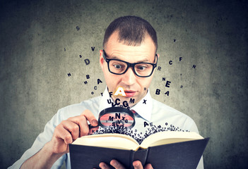Amazed man reading a book with letters flying away from it