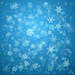 Fototapeta na wymiar Christmas background of complex blurred and clear falling snowflakes in light blue colors with bokeh effect