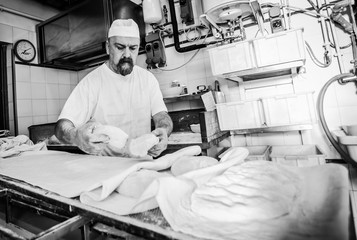 Production of baked bread with a wood oven in a bakery.