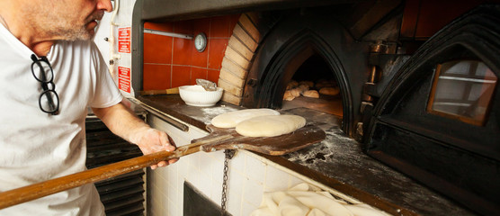 Production of baked bread with a wood oven in a bakery.