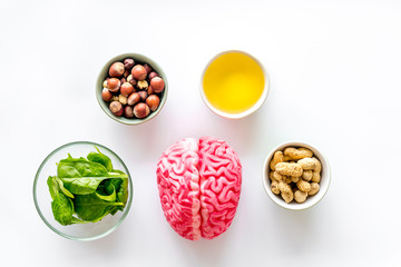 Energy food for brain work with peanut, hazelnut, seed-oil, spinage on white background top view
