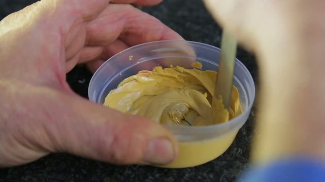 A man dilutes the putty on the metal hardener and mixes it.