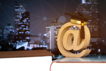 Concept of success business and long distance study abroad university education of knowledge with Email address symbol, Graduation cap on textbook, blur light building city network contact background.