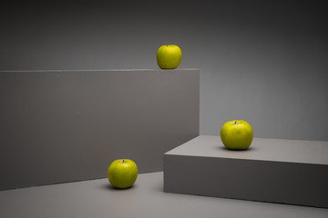 three green apple on grey box