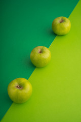 Three Green apple on green color paper background
